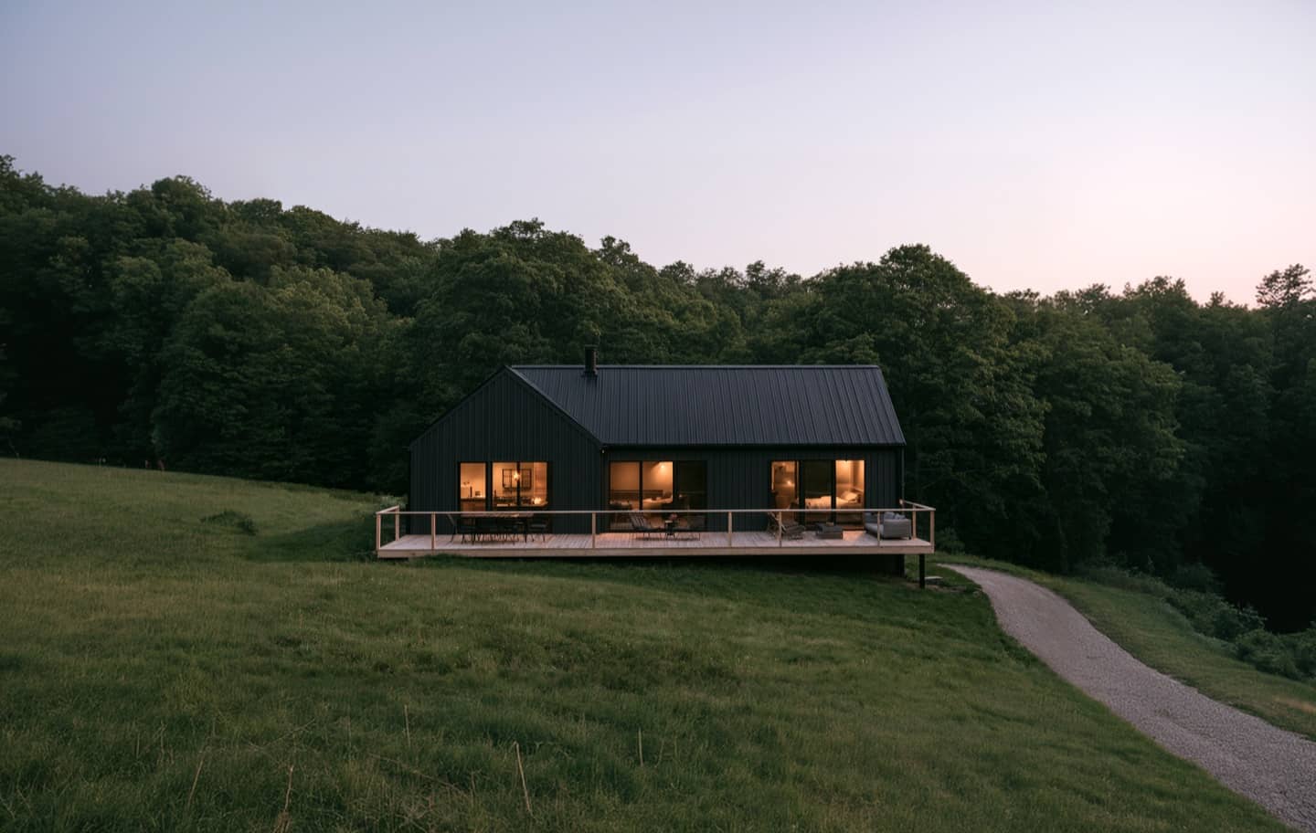 Modernes Haus mit warm beleuchteten Fenstern in der Dämmerung
